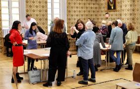 Zajęcia warsztatowe, uczestnicy spotkania podzieleni na kilka mniejszych grup, pracują wokół stołów