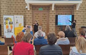 Uczestnicy siedzą na krzesłach, słuchają wykładu dr Joanny Filipczyk.