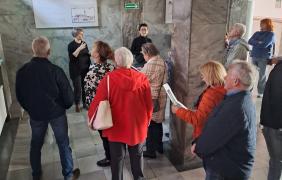 Ludzie oglądają witraże w holu ratusza.