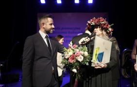 kobieta w wianku z kwiatami i gratulujący jej mężczyzna 