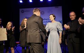 prezydent miasta uściskający dłoń laureatce nagrody