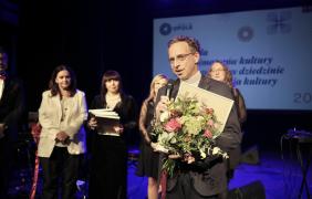 laureat nagrody z kwiatami, przemawiający do mikrofonu