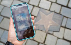 telefon z wyświetlanym audioprzewodnikiem, w tle gwiazda w alei gwiazd