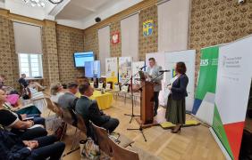 Na środku sali przemawiają do mikrofonów moderatorzy konferencji