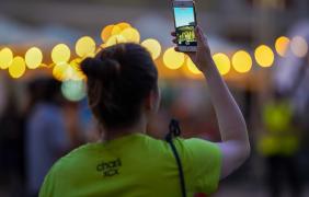 kobieta stoi plecami, ogląda koncert, telefon komórkowy