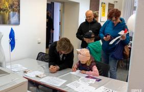 dziecko z rodziacami, rozwiązuje łamigłówki