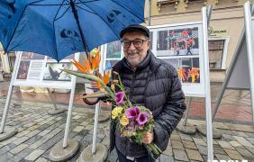 artysta z bukieten kwiatów i parasolem
