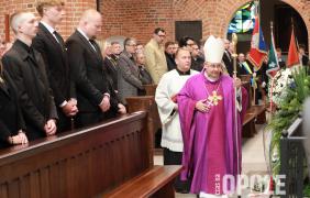 żałobnicy w kościelnych ławkach, ksiądz biskup