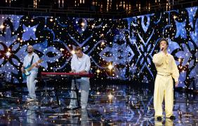 kilka mężczyzn stoi na scenie, wokalista i muzycy
