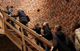 osoby wchodzą na wieżę po schodach